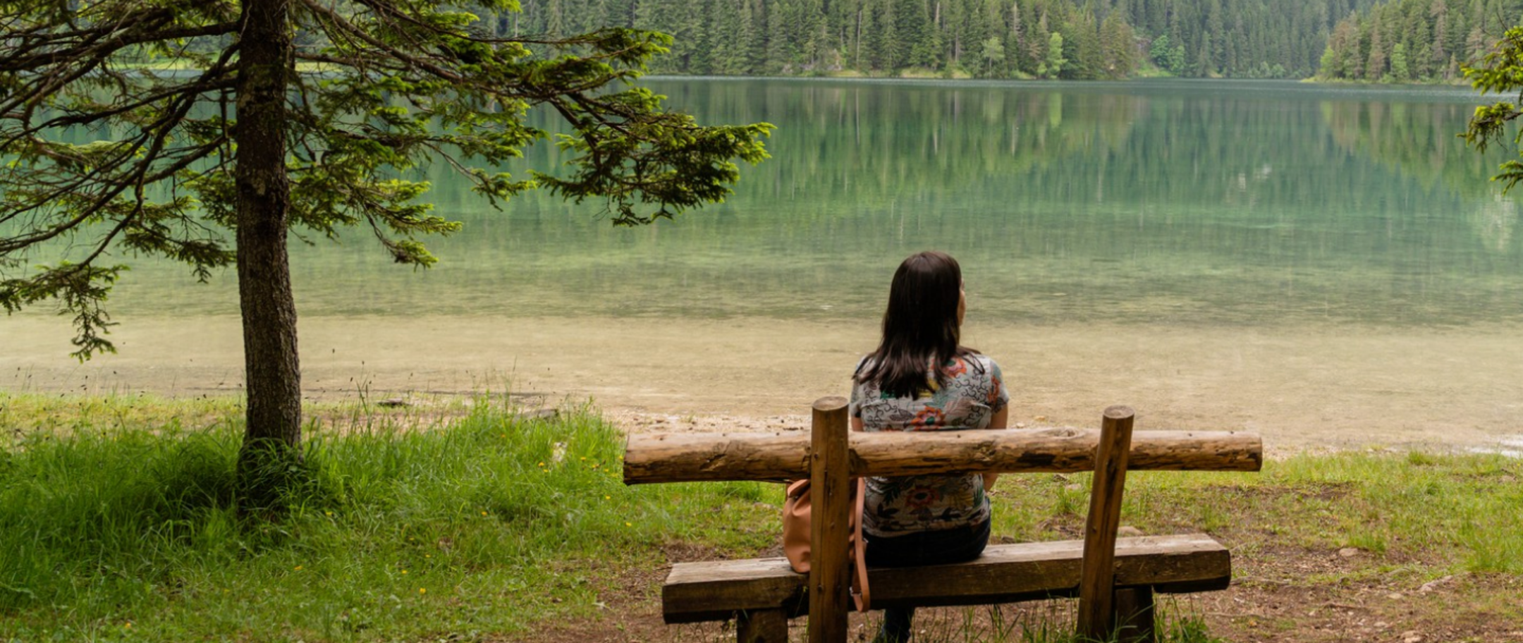 woman on a bench overlooking a lake