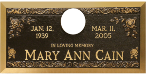 Bronze memorial featuring edge designs and roses in the corners.