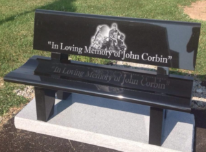 Jet Black park bench monument sitting on a concrete slab in a cemetery laser etched with image of motorcyclist and his bike